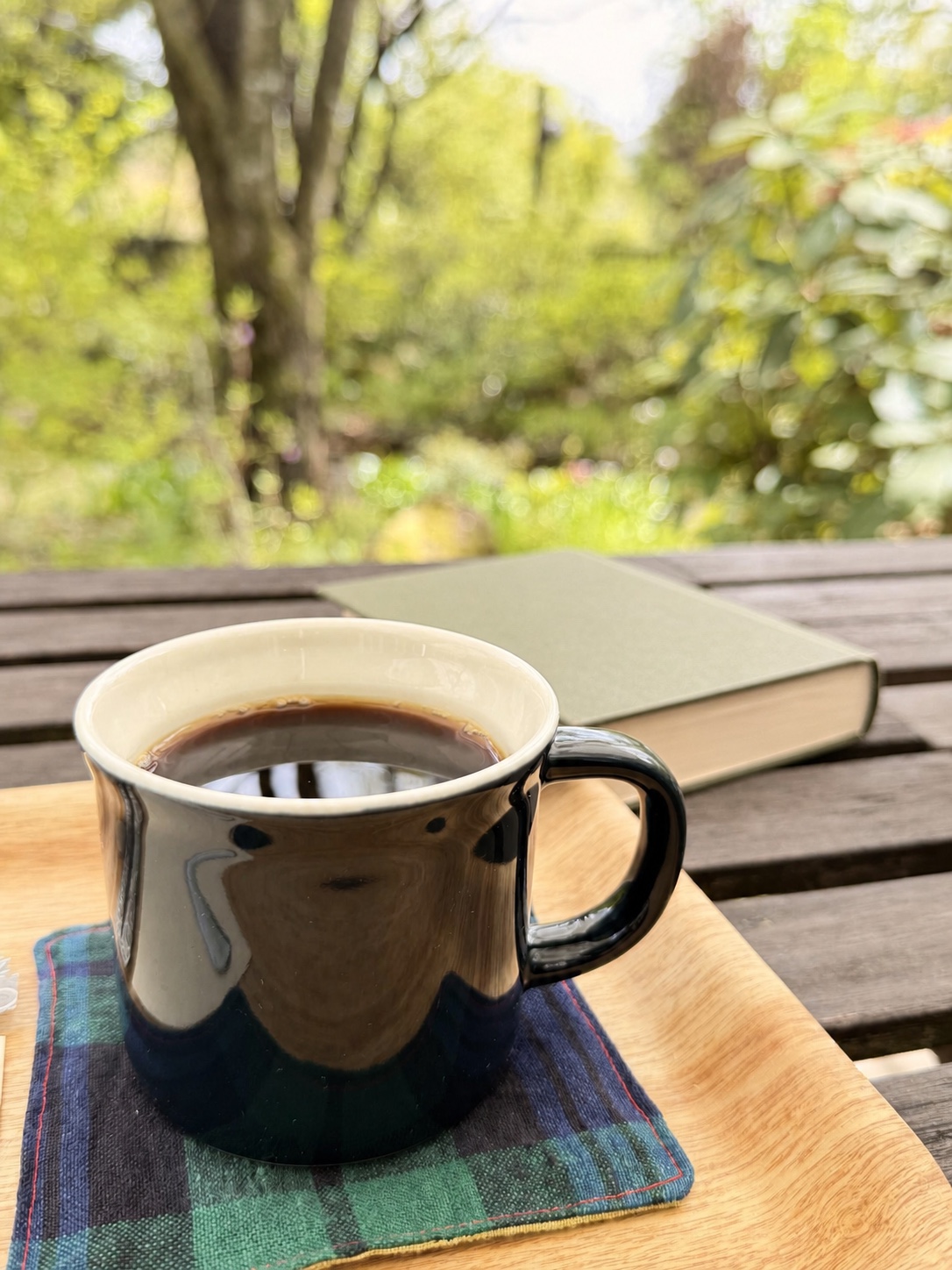 庭のテーブルに置かれたコーヒーと本